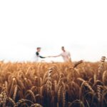 Zwei Personen stehen auf einem Weizenfeld